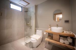 a bathroom with a toilet and a sink and a shower at Dusit Buncha Koh Tao by Riya Group in Ko Tao