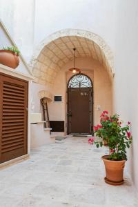 特里卡塞Corte degli Angeli - residence typical Salento的有门和盆栽的走廊