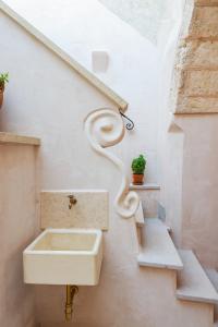 特里卡塞Corte degli Angeli - residence typical Salento的一间带水槽和楼梯的浴室