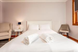 a bedroom with a white bed with towels on it at Burnock Lodge with Hot Tub in Ayr