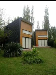 a house with two windows in a grass field at Minicasas in Villa Ciudad Parque