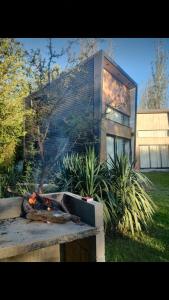 a fire in a fire pit in front of a house at Minicasas cerca del rio Los Reartes in Villa Ciudad Parque +11 photos