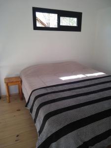 a bed in a room with a window at Minicasas in Villa Ciudad Parque
