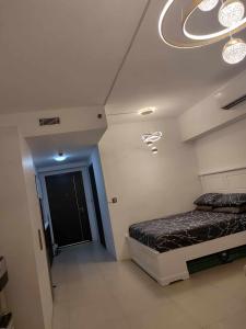 a bedroom with a bed and a chandelier at Aeon tower Davao exclusive studio unit in Davao City +20 photos