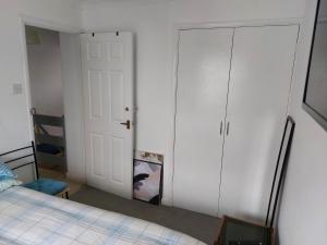 a bedroom with a bed and a closet and a door at Bude Homestay in Stratton +9 photos