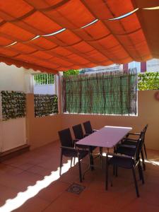 ein Tisch und Stühle unter einer orangefarbenen Decke in der Unterkunft PUERTA MARINA in La Redondela