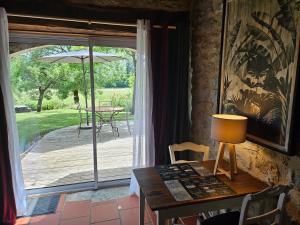 a dining room with a table and a sliding glass door at LA GRANGE in Padirac
