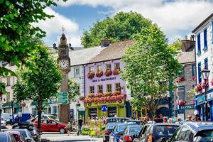 a busy city street with cars and a clock tower at No 12 Bridge Street - Town Centre Apartment in Westport