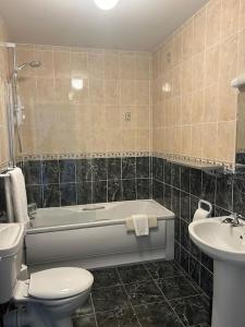 a bathroom with a tub and a toilet and a sink at No 12 Bridge Street - Town Centre Apartment in Westport +35 photos