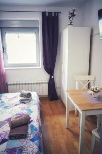 sypialnia z łóżkiem, stołem i oknem w obiekcie Room Armani w Rovinj