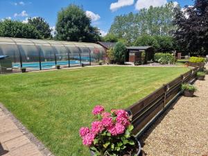 un giardino con fiori rosa di fronte a un edificio di Cypress Log Cabins Accommodation a Godshill