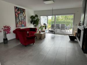 Una sala de estar con un sofá rojo y una chimenea. en exklusives Haus mit Pool&Sauna, en Hamm