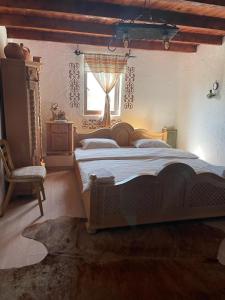 a bedroom with a large bed and a window at Къща за гости РАЙ 10човека in Boykovtsi