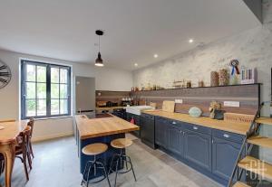 a large kitchen with blue cabinets and a table at Azalée - Azay sur Cher in Azay-sur-Cher +39 photos