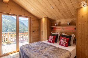une chambre avec un lit et une grande fenêtre dans l'établissement 200 m des télécabines, Cheminée & Cosy, à Champagny-en-Vanoise