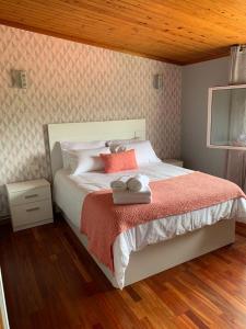 una camera da letto con un letto bianco con un soffitto in legno di Casa das Roma a Cambados