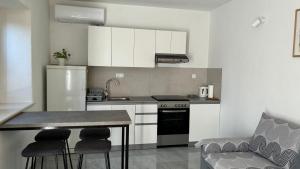 a kitchen with white cabinets and a table and chairs at Holiday house Misetic in Selca