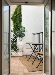 een open deur met een tafel en een plant bij Preciosa casa con terraza in Vejer de la Frontera
