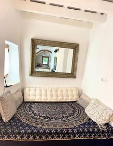 een woonkamer met een bank en een spiegel bij Preciosa casa con terraza in Vejer de la Frontera