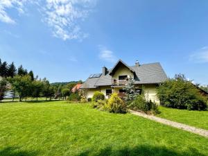 a house with a green lawn in front of it at Dolina Obiecana in Kalnica