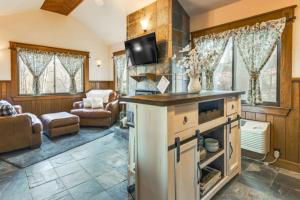 Una sala de estar con cocina y una sala de estar con sofá. en Village 37 Stone Cabin, en Roundhill