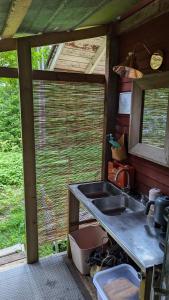 an outdoor kitchen with a sink and a window at Bell-tent Noord in Lappeenranta