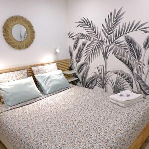 a bedroom with a large bed with a tropical wallpaper at Appartement en plein centre à 100m du port in Mèze