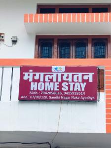 a sign on the side of a building at Mangalayatan Home Stay Ayodhya in Faizābād