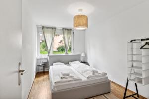 ein weißes Schlafzimmer mit einem Bett und einem Fenster in der Unterkunft Spacious Apartment in Zurich in Zürich