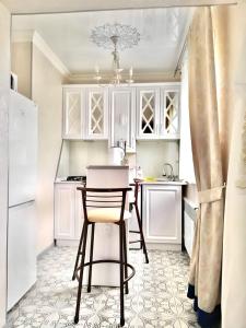 a kitchen with white cabinets and a table and a chair at Квартира на Арбате 1 ком in Shymkent +5 photos