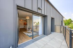 een balkon van een huis met glazen schuifdeuren bij OVELIA Fouesnant - Les Allées de Kervihan in Fouesnant