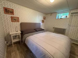 ein kleines Schlafzimmer mit einem Bett und einem Tisch in der Unterkunft Emma's country cottage in southern Sweden in Älghult