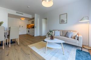 een woonkamer met een bank en een tafel bij OVELIA Fouesnant - Les Allées de Kervihan in Fouesnant