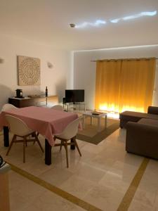 una sala de estar con una mesa y un sofá en Luxury Apartment, Marina, Beach & Pool II, en Portimão