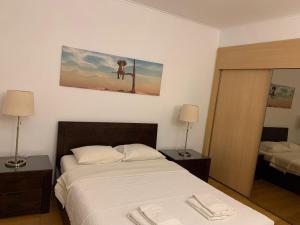 Un dormitorio con una cama y dos lámparas y un cuadro. en Luxury Apartment, Marina, Beach & Pool II, en Portimão
