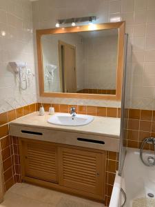 un baño con lavabo y espejo en Luxury Apartment, Marina, Beach & Pool II, en Portimão