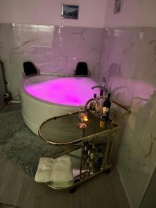 Una bañera con iluminación rosa en un baño. en Apartman Mont, Lux & Jacuzzi - Jahorina, en Jahorina 29 fotos más