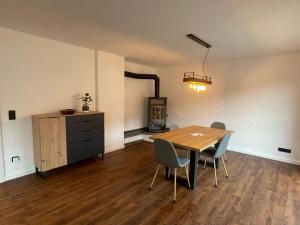 a dining room with a table and chairs and a stove at Ferienwohnung Am Kreuzberg in Schleiden