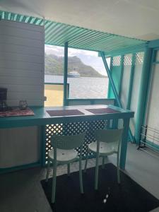 a table and chairs on a boat with a view of the water at Cottage Beach in Orufara +10 photos