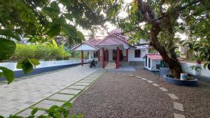a small house with a tree in front of it at Mampilly Guest House in Kottayam +12 photos