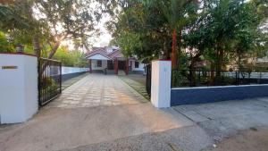 a driveway with a gate in front of a house at Mampilly Guest House in Kottayam