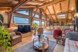 una sala de estar con techos de madera y una gran ventana. en Le Mont Farm, en Servoz
