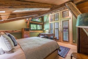 1 dormitorio en una cabaña de madera con cama y escritorio en Le Mont Farm, en Servoz