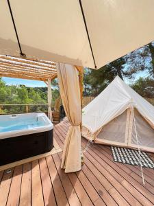 a hot tub and a tent on a wooden deck at LOVE ROOM Tente Lodge spa MFG chez C&C, exclusivement réservée aux ADULTES in Cantaron