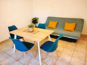 a table and chairs with a couch in a room at Cosy Courtesoun in Courthézon