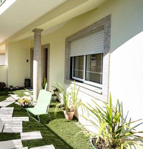 a patio with a white chair in front of a house at Charming Cozy Retreat - Terrace & Private Balcony in Coimbra +11 photos