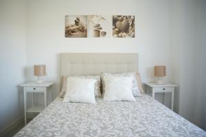 a bedroom with a bed with two white night stands at Playa Marinsa Torre del Mar in Torre del Mar +35 photos
