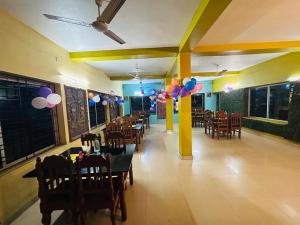 桑蒂尼盖登Gitanjali Hotel & Restaurant的一间带气球和桌椅的用餐室
