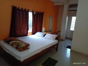 桑蒂尼盖登Gitanjali Hotel & Restaurant的一间带大床的卧室，带窗户
