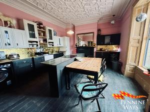 una cucina con pareti rosa, tavolo e sedie di Greystonedale Mansion and House, Haltwhistle a Haltwhistle